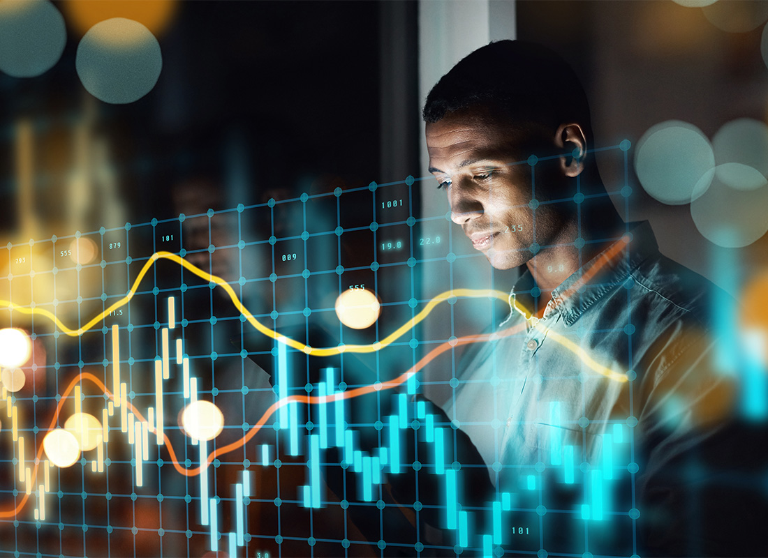 About Our Agency - Portrait of a Young Businessman Working on Business Analytics Inside a Modern Office at Night with an Overlay of a Statistics Chart